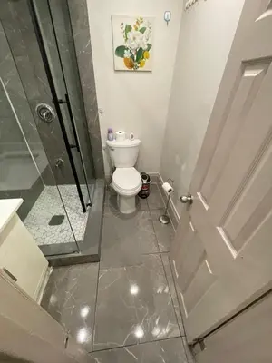 a bathroom with a toilet and a glass shower at FIFA CENTRAL TORONTO-DIRECT TO BMO FIELD-Live Game Atmosphere-Free Wifi in Toronto