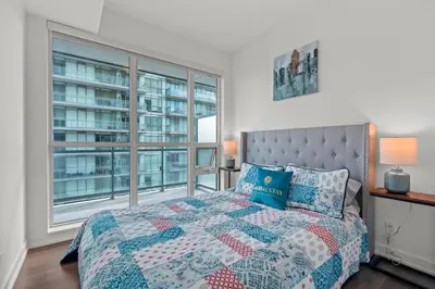 a bedroom with a bed and a large window at Cozy 2 Bedroom Condo in Dunfield Ave Downtown Toronto in Toronto