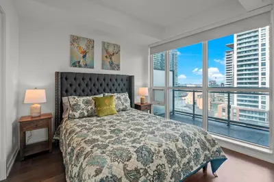 a bedroom with a bed and a large window at Cozy 2 Bedroom Condo in Dunfield Ave Downtown Toronto in Toronto