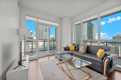 a living room with a couch and large windows at Cozy 2 Bedroom Condo in Dunfield Ave Downtown Toronto in Toronto