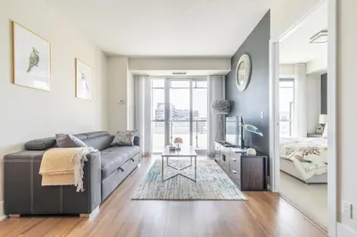 a living room with a couch and a bed at Paradise Birds 1 Bedroom Condo in Downtown Toronto in Toronto