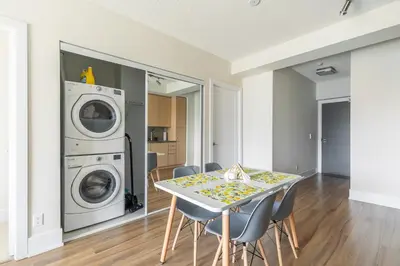 a laundry room with a table and a washing machine at Paradise Birds 1 Bedroom Condo in Downtown Toronto in Toronto