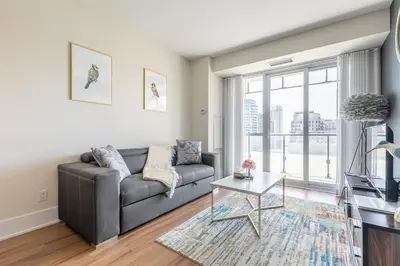 a living room with a couch and a table at Paradise Birds 1 Bedroom Condo in Downtown Toronto in Toronto