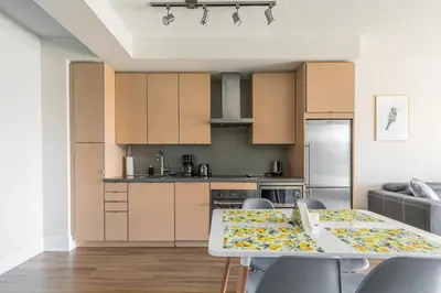 a kitchen with a table and chairs in a room at Paradise Birds 1 Bedroom Condo in Downtown Toronto in Toronto