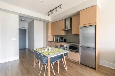 a kitchen with a table and chairs in a room at Paradise Birds 1 Bedroom Condo in Downtown Toronto in Toronto
