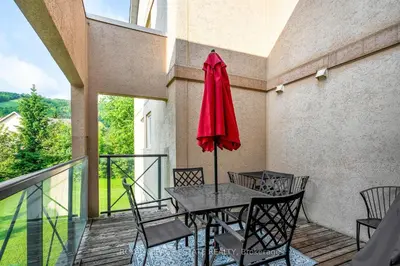 a patio with a table and chairs and a red umbrella at Mountain Home in the Heart of Blue Mountain Village in Blue Mountains