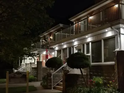 a house with lights on the side of it at night at Ambassador B&B Guest Home in Stratford
