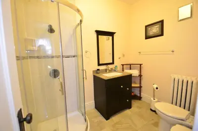 a bathroom with a shower and a sink and a toilet at Ambassador B&B Guest Home in Stratford