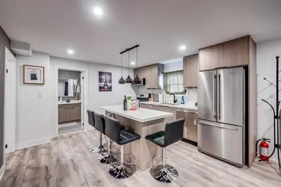 a kitchen with a refrigerator and a table with chairs at Niagara 3 Bed Unit Near the Falls in Niagara Falls