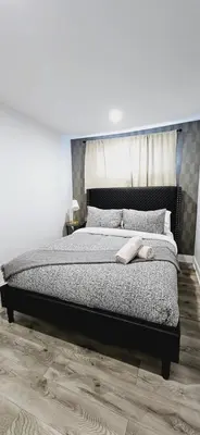 a bedroom with a large bed with a wooden floor at Niagara 3 Bed Unit Near the Falls in Niagara Falls