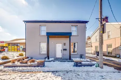 a white house with a door in the snow at Niagara 3 Bed Unit Near the Falls in Niagara Falls