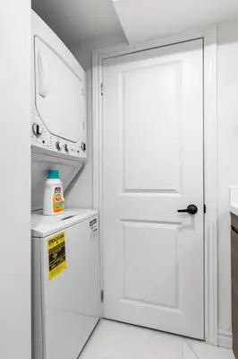 a white door in a kitchen with a refrigerator at High Park Oasis Modern 1B1B, Kitchen, Laundry in Toronto