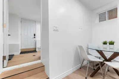 a dining room with a table and white chairs at High Park Oasis Modern 1B1B, Kitchen, Laundry in Toronto