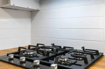 a black stove top oven in a kitchen at High Park Oasis Modern 1B1B, Kitchen, Laundry in Toronto