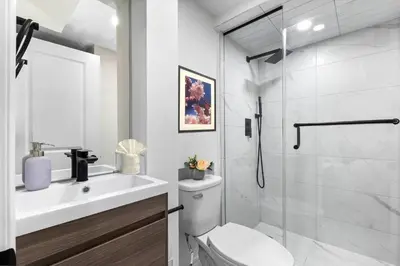 a bathroom with a shower and a toilet and a sink at High Park Oasis Modern 1B1B, Kitchen, Laundry in Toronto