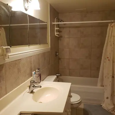 a bathroom with a sink and a toilet and a tub at Homely Inn in Toronto