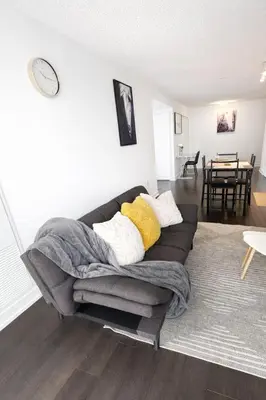 a living room with a couch and a table at RivetStays - Dan Leckie Suite in Toronto