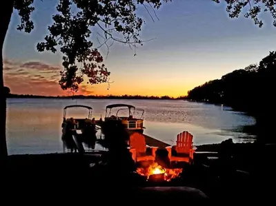 two boats are docked on a lake at sunset at Sandbanks Beach Cottage in West Lake