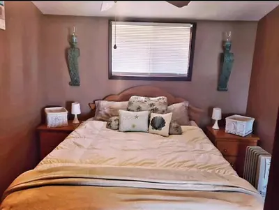 a bedroom with a large bed with pillows on it at Sandbanks Beach Cottage in West Lake