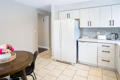 a kitchen with a table and a white refrigerator at Spacious & Cozy in the Heart of Town in London
