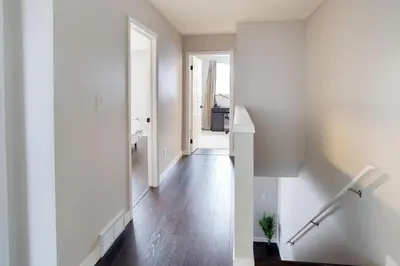 a hallway of a home with white walls and wooden floors at Spacious & Cozy in the Heart of Town in London