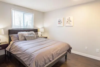 a bedroom with a bed with two lamps and a window at Spacious & Cozy in the Heart of Town in London