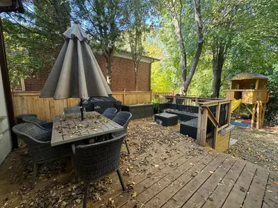 a patio with a table and chairs and an umbrella at Spacious 4-Bedrooms Friendly House Toronto-Parking in Markham