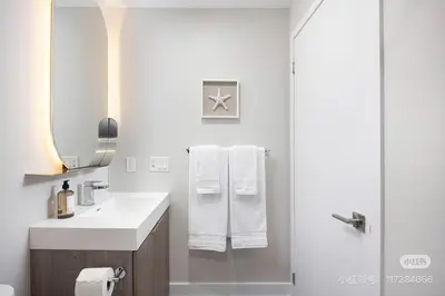 a bathroom with a sink and a shower with towels at KK Hotel in Markham