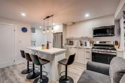 a kitchen with a counter and some chairs in it at Modern 2 Bed Unit Near the Falls in Niagara Falls