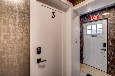 an exit sign on a wall next to a white door at Modern 2 Bed Unit Near the Falls in Niagara Falls