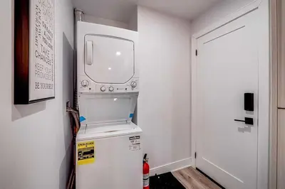 a small kitchen with a refrigerator with a window at Modern 2 Bed Unit Near the Falls in Niagara Falls