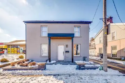 a building with a white door in the snow at Modern 2 Bed Unit Near the Falls in Niagara Falls