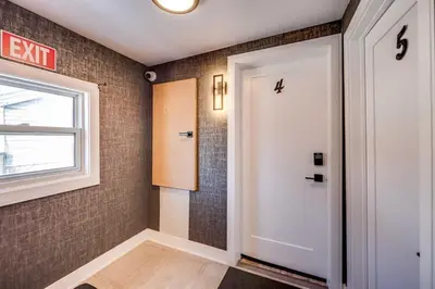 a hallway with a white door and a window at Niagara Falls 2BR Unit in Niagara Falls