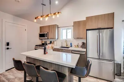 a kitchen with a refrigerator and chairs in it at Niagara Falls 2BR Unit in Niagara Falls