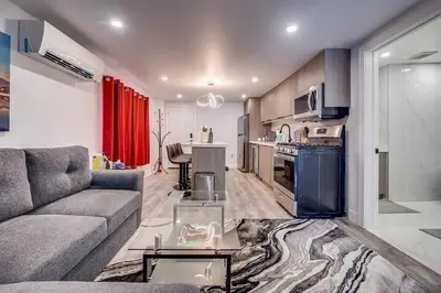 a living room with a couch and a kitchen at Modern 2BR Unit Near the Falls in Niagara Falls
