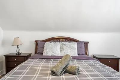 a bed with two pillows on top of it at 5 Bedroom House - 1 Block from the Falls in Niagara Falls
