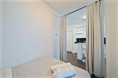 a white bedroom with a bed with two towels on it at Skyline Stays Chic 2BR Steps from Everything in Toronto