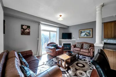a living room with leather furniture and a fireplace at Thrilling Homey Escape In Toronto Area in Ajax