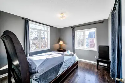 a bedroom with a bed and two windows at Thrilling Homey Escape In Toronto Area in Ajax