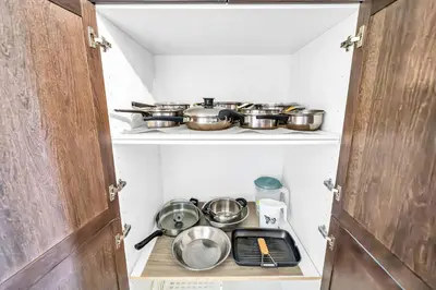 a small kitchen with pots and pans on a shelf at Exhilarating Castle Vibes In Toronto Area in Ajax