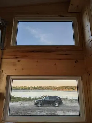 a car parked in a room with a window at Woodrush Cabin a Charming Lakefront Tiny Cabin in Victoria Road
