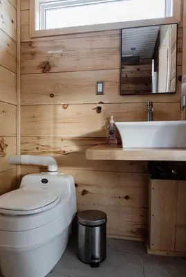 a bathroom with a toilet and a sink at Woodrush Cabin a Charming Lakefront Tiny Cabin in Victoria Road
