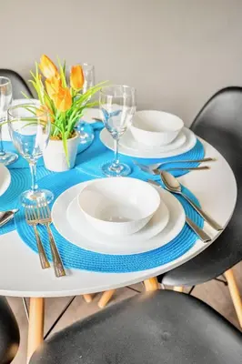 a table with blue and white plates and silverware at Charming Newly Renovated Condo - Glenview West in Hamilton