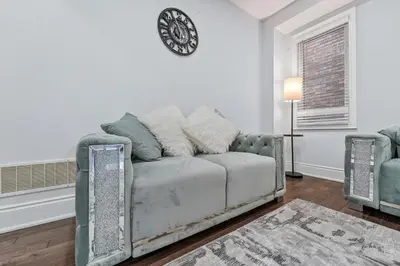 a living room with a couch and a clock on the wall at Spacious Modern 5BR Home Sleeps 13 Family home in Milton