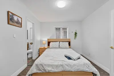 a bedroom with a large bed in a white room at Spacious Modern 5BR Home Sleeps 13 Family home in Milton