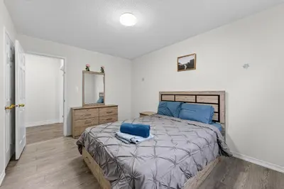 a bedroom with a bed with blue pillows on it at Spacious Modern 5BR Home Sleeps 13 Family home in Milton