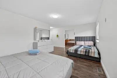 a white bedroom with a bed and a mirror at Spacious Modern 5BR Home Sleeps 13 Family home in Milton