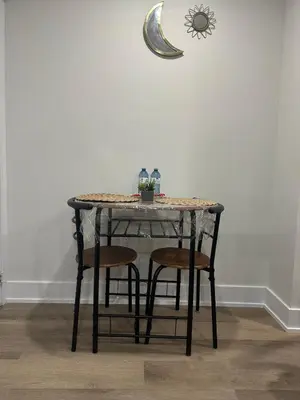 a table with four chairs and a table with the moon on the wall at Cozy Basement Studio with Private Bathroom and Kitchen in Vaughan