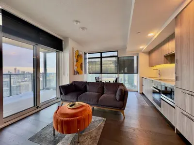 a living room with a brown couch and a table at Luxury 76 floor 2B2B Downtown Toronto Skyline View in Toronto