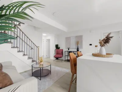 a living room with white walls and a staircase at 2BR Penthouse Rooftop, Parking, Close to the Falls in Niagara Falls